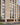 Modern apartment building with beige brick facade and glass windows.