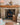 A log burning stove sits centrally in a brick slip fireplace, the cream and beige tiles around the front to form pillars.