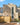 A house clad in cream brick slips, a square art deco design with a long central window.