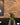 Some green foliage is central between two booths. Red rustic brick slips are on the wall behind.