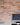 A brick slip wall in red and orange tones with blue painted ones, and cream pointing mortar.