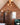 A gable end with a window clad in red/orange brick slips in a rustic style with blue statements. Cord lights hang from a beam