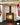A brick slip fireplace in a light orange/red colour with stark white pointing, the fire is on.
