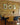 4 pendant lights hang from a ceiling above a wooden table. The back wall has yellow London brick slips installed.