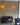 Two wall lights sit on an ochre brick slip backdrop, with white and black painted ones scattered around.