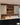 Black kitchen units on the floor, grey ones on the wall, and classic creased red brick slips cover the back wall.