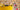 a yellow bucket and red spirit level infront of un-pointed brick slips with spacers still in.