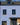 Blue brick house with black windows and a dark roof
