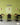 Modern cafe interior with green glazed brick slip walls, wooden tables, and black chairs.