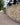Brick wall along a paved pathway with trees in the background