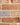 A close up of cream brick slip pointing mortar on a red/orange brick wall.